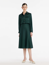 a lady in a dark green triacetate midi skirt with a matching shirt
